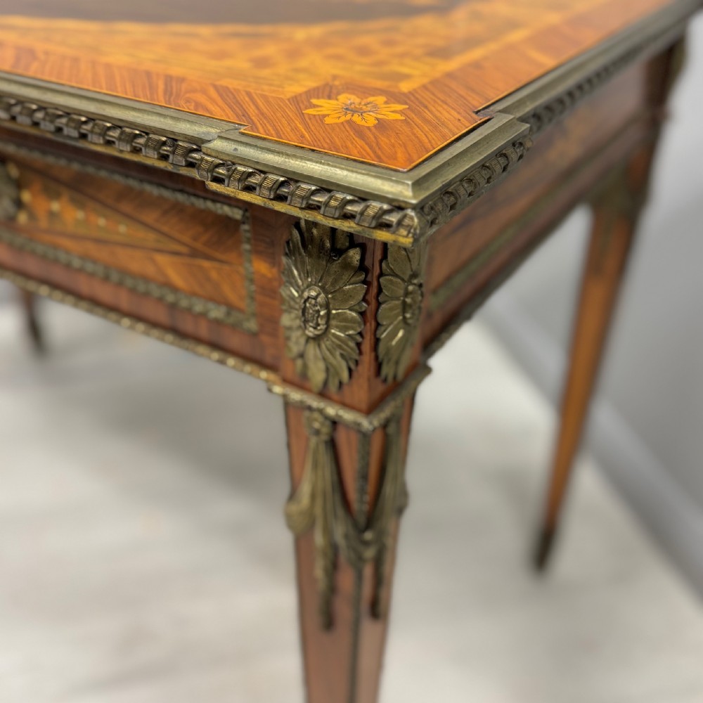 A French Louis XVI style kingwood centre table featuring intricate floral marquetry, brass mounts, a central porcelain plaque, and tapered square legs. View VIII