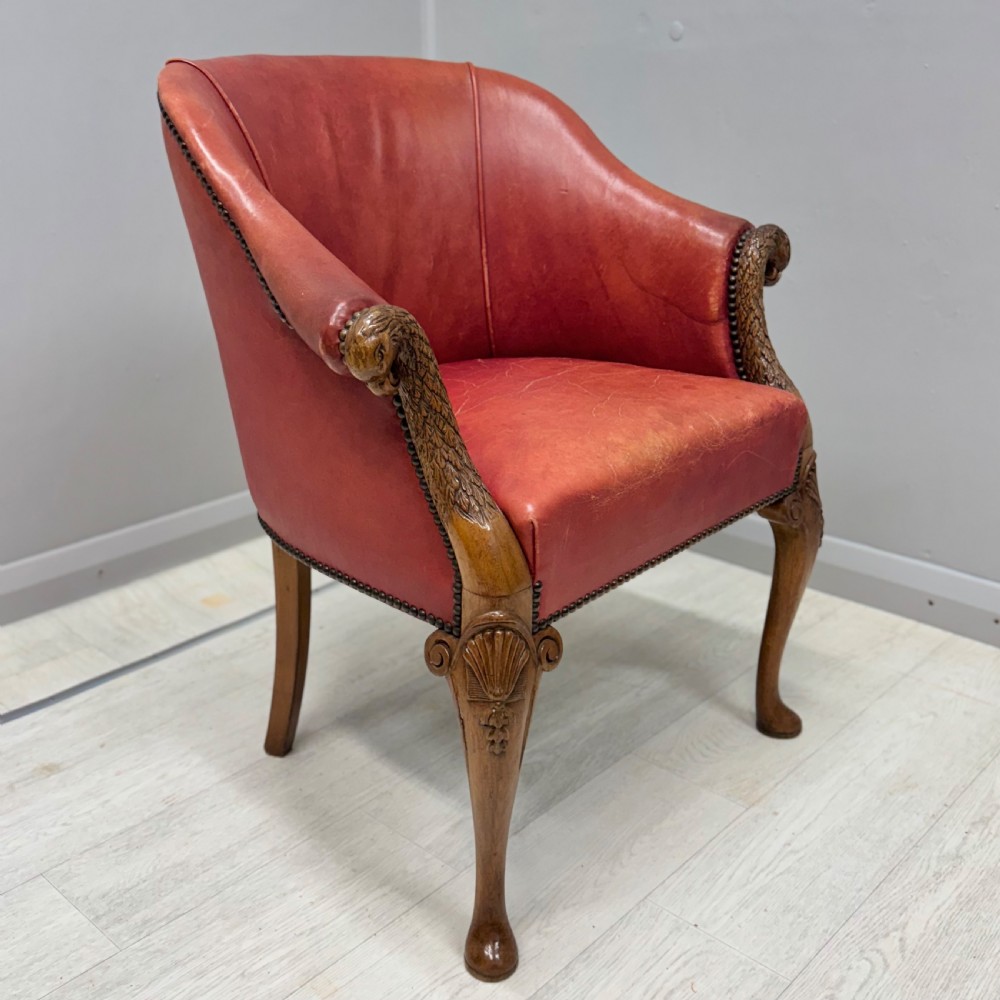 A red leather tub back armchair featuring carved mahogany cabriole legs, eagle head armrests, and brass studded trim. View II