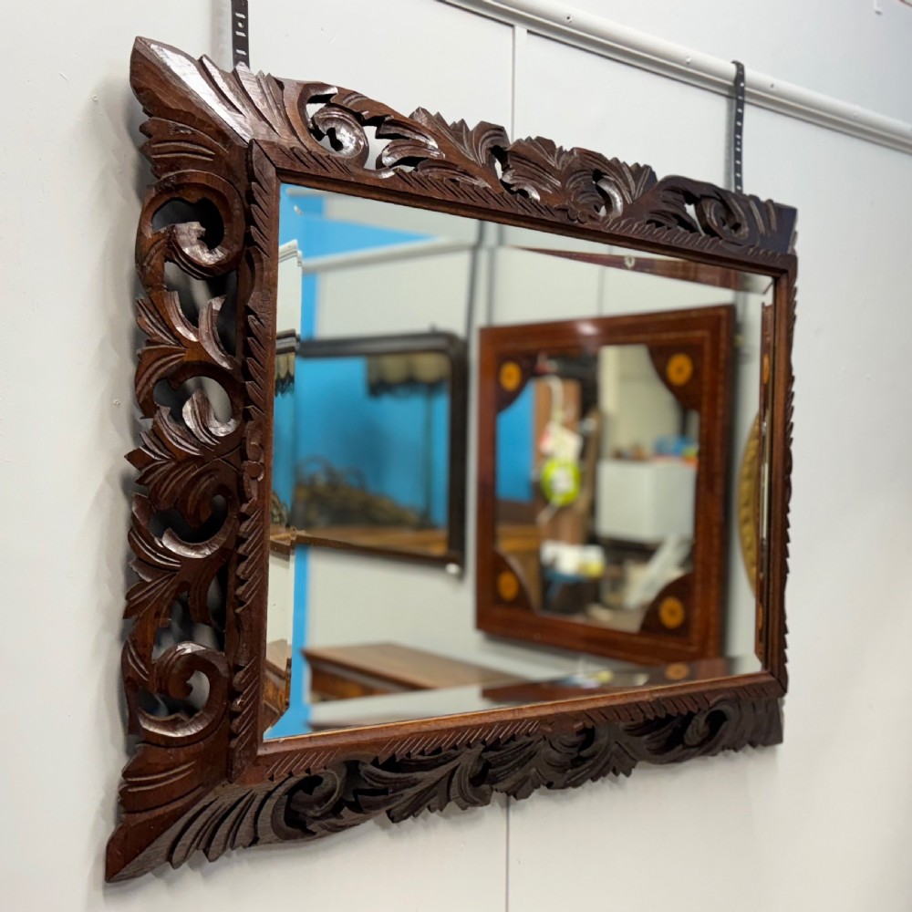 A rectangular 19th-century French wall mirror featuring a hand-carved dark oak frame decorated with openwork scrollwork and foliage motifs. View IV