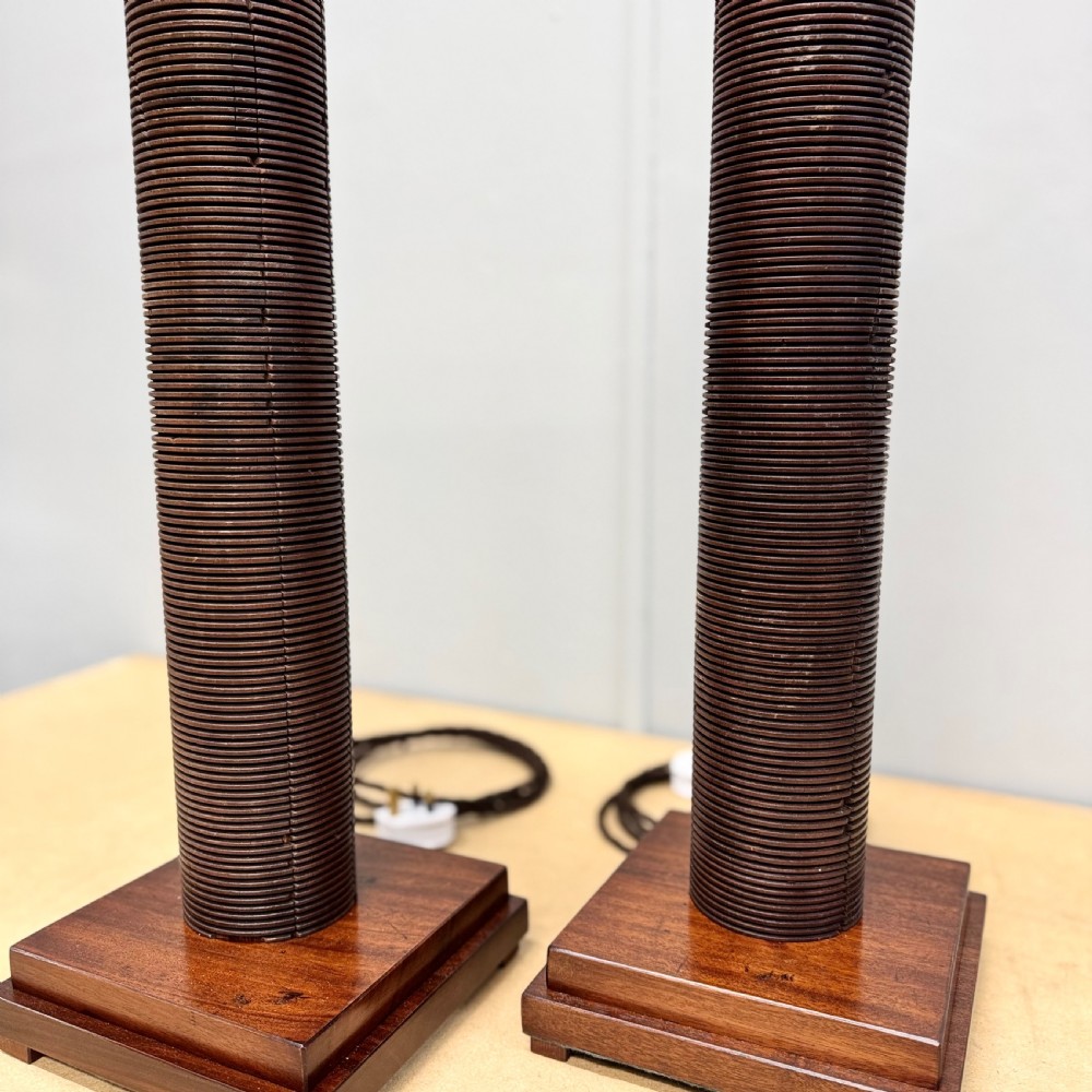 A matching pair of tall, dark wood table lamp bases featuring reeded cylindrical columns set on square plinths with brass bulb holders. View VI