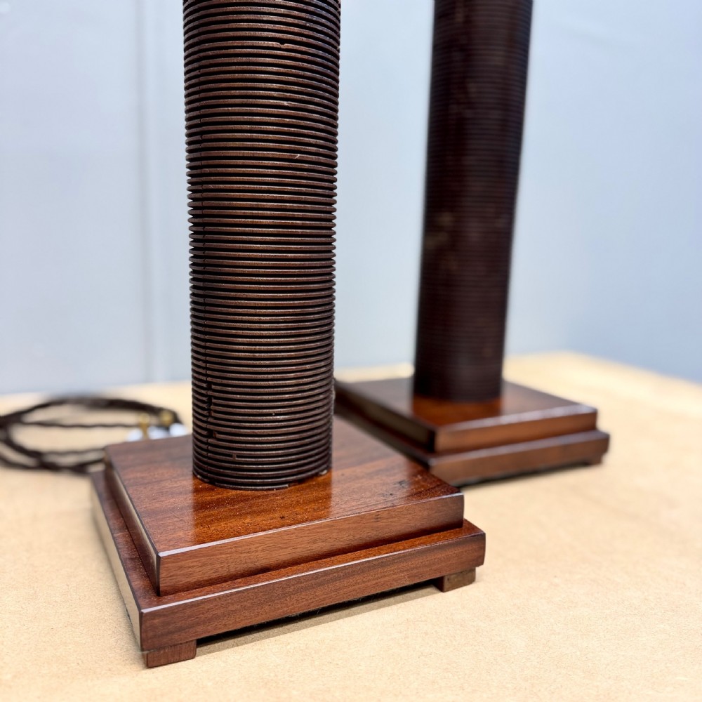 A matching pair of tall, dark wood table lamp bases featuring reeded cylindrical columns set on square plinths with brass bulb holders. View VII