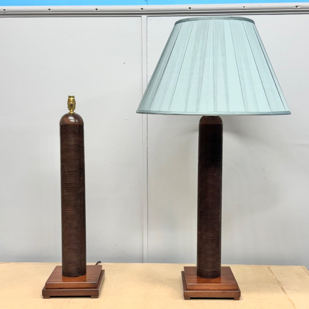 A matching pair of tall, dark wood table lamp bases featuring reeded cylindrical columns set on square plinths with brass bulb holders. View VIII