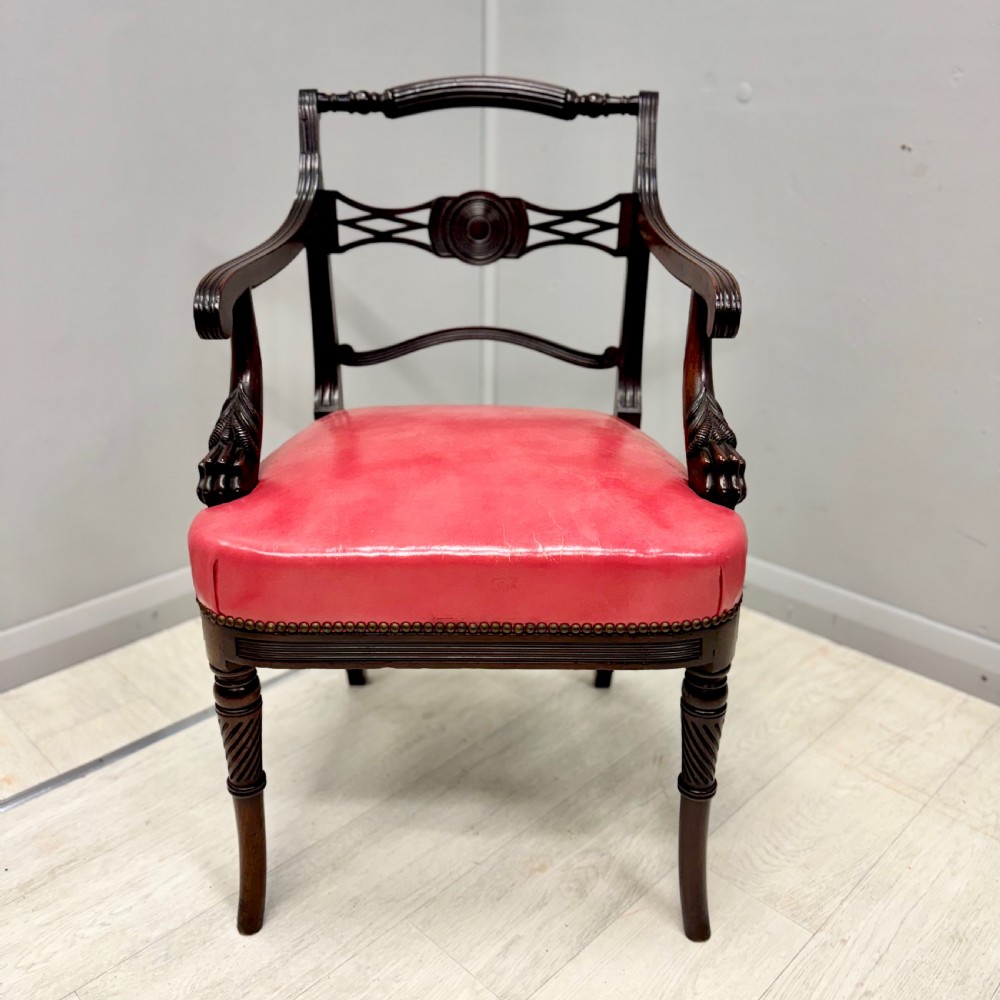 A set of four dark mahogany Regency style elbow chairs featuring carved rosettes, reeded arms, and red leather seats. View II