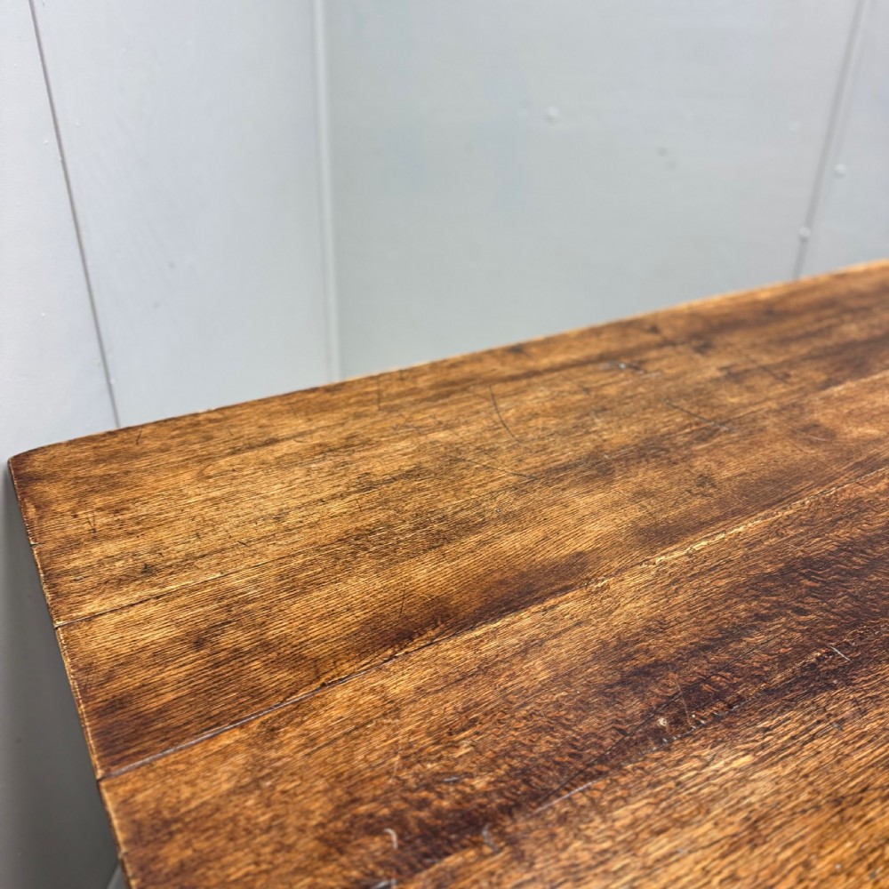 A large rectangular oak farmhouse dining table with a plank top, six turned legs, and a low H-stretcher base. View VIII