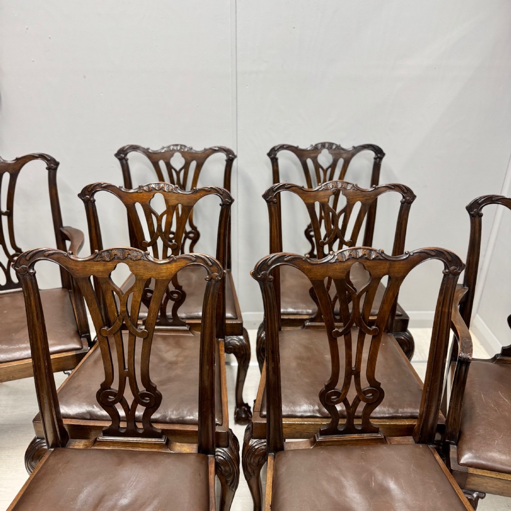 A set of eight Georgian style mahogany dining chairs featuring pierced back splats, brown leather seats, and cabriole legs ending in ball and claw feet. View II