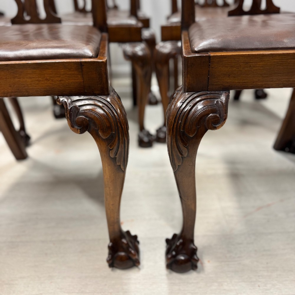 A set of eight Georgian style mahogany dining chairs featuring pierced back splats, brown leather seats, and cabriole legs ending in ball and claw feet. View III