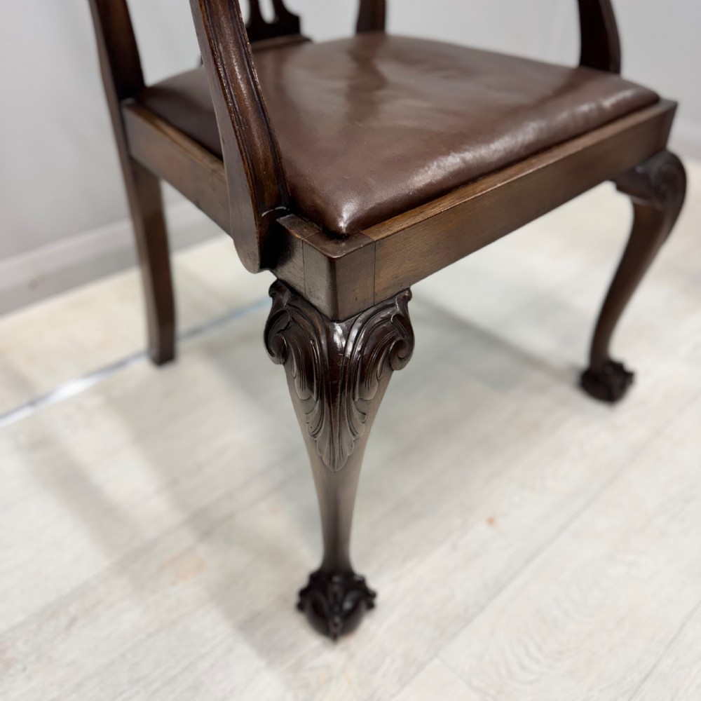 A set of eight Georgian style mahogany dining chairs featuring pierced back splats, brown leather seats, and cabriole legs ending in ball and claw feet. View VI
