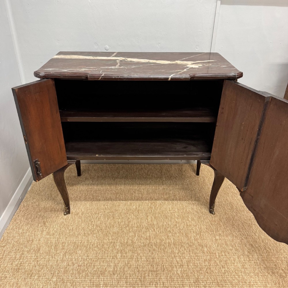 An early nineteenth-century French style marquetry commode cabinet with a marble top, cabriole legs, central inlaid architectural landscape scene, and decorative brass mounts. View II