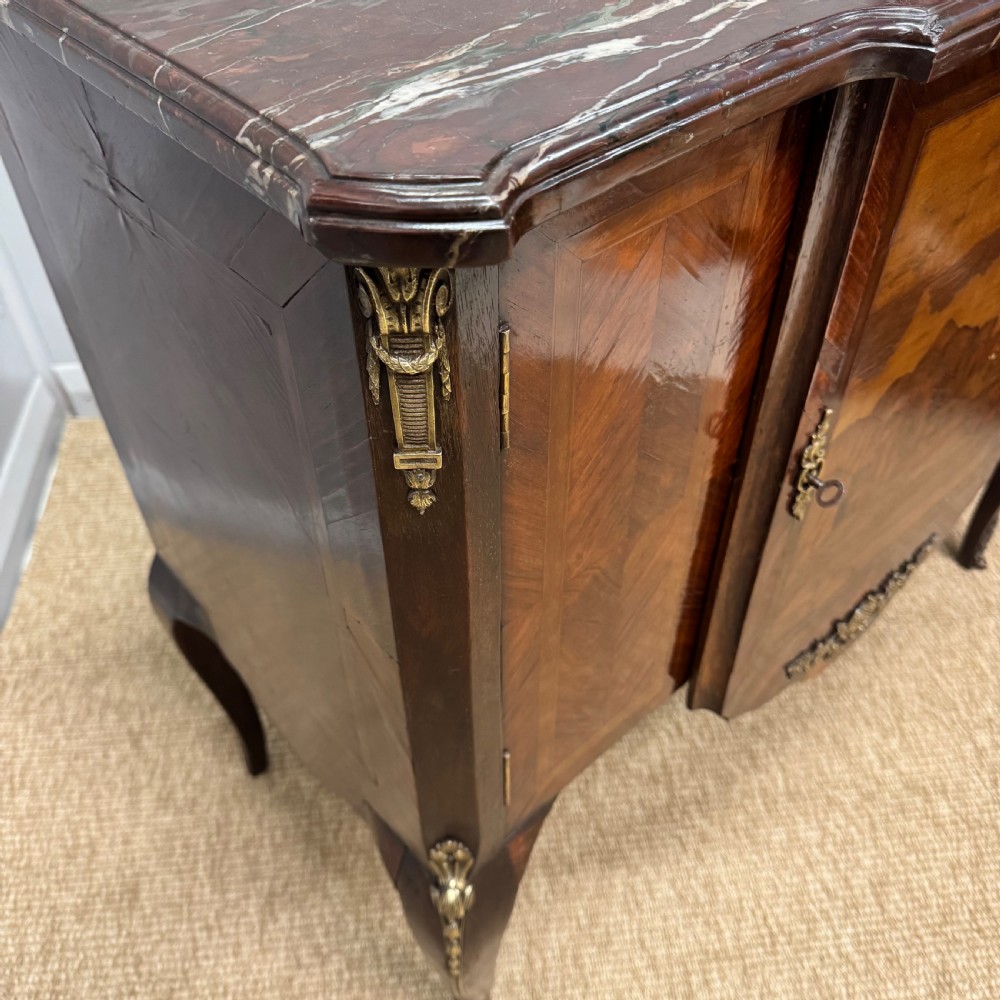 An early nineteenth-century French style marquetry commode cabinet with a marble top, cabriole legs, central inlaid architectural landscape scene, and decorative brass mounts. View VII