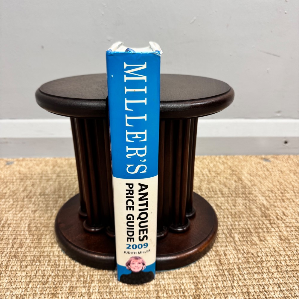 A pair of dark mahogany semi-circular bookends shaped like classical fluted columns. View III