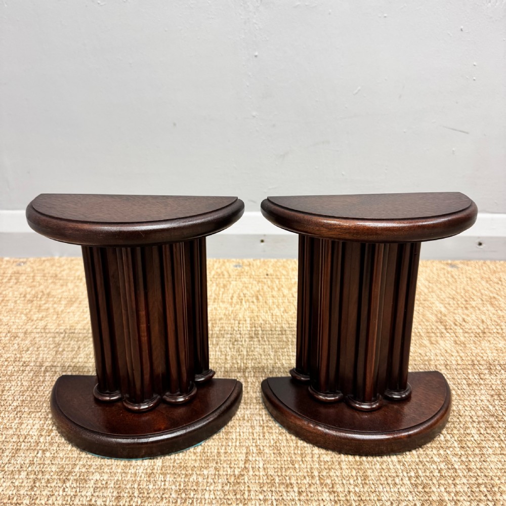 A pair of dark mahogany semi-circular bookends shaped like classical fluted columns. View V