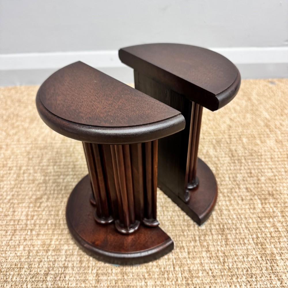 A pair of dark mahogany semi-circular bookends shaped like classical fluted columns. View VII