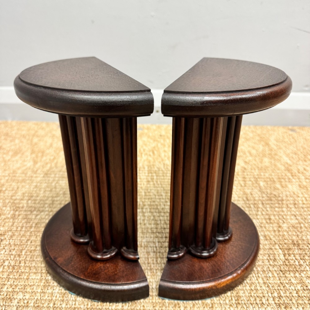 A pair of dark mahogany semi-circular bookends shaped like classical fluted columns. View VIII