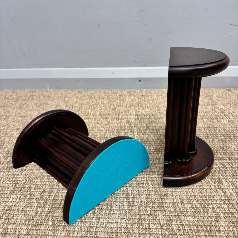 A pair of dark mahogany semi-circular bookends shaped like classical fluted columns. View IX