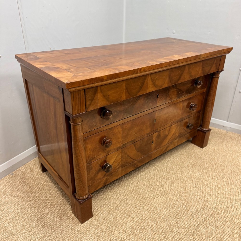 A 19th-century French cherry wood commode featuring three lower drawers with turned knobs, a top frieze drawer, and side columns on block feet. View II
