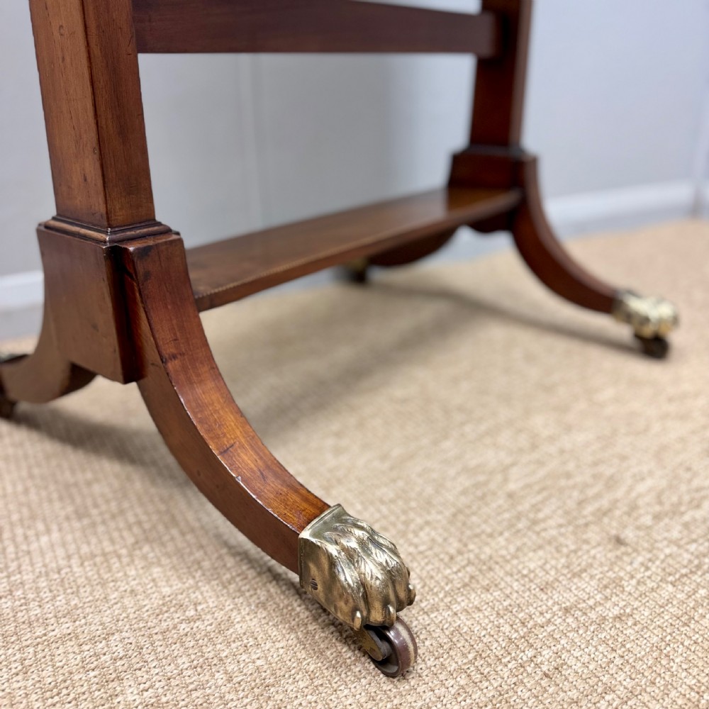 A Regency mahogany cheval mirror featuring a rectangular swivelling mirror frame, turned finials, boxwood inlay, and splayed legs ending in brass castors. View II