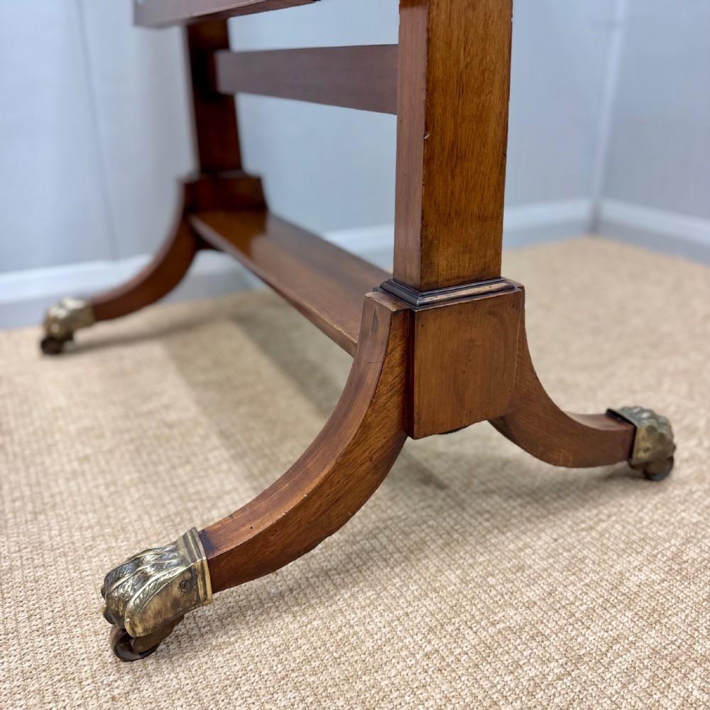 A Regency mahogany cheval mirror featuring a rectangular swivelling mirror frame, turned finials, boxwood inlay, and splayed legs ending in brass castors. View III