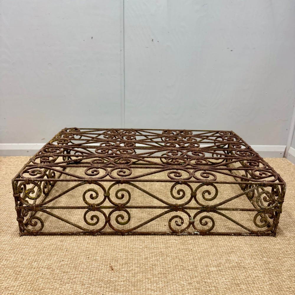 A low rectangular French wrought iron table with ornate C-scroll patterns and a weathered rust finish. View II