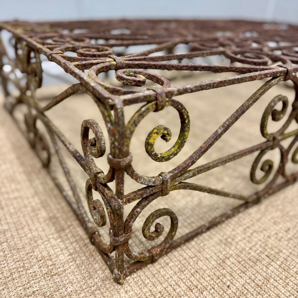 A low rectangular French wrought iron table with ornate C-scroll patterns and a weathered rust finish. View III