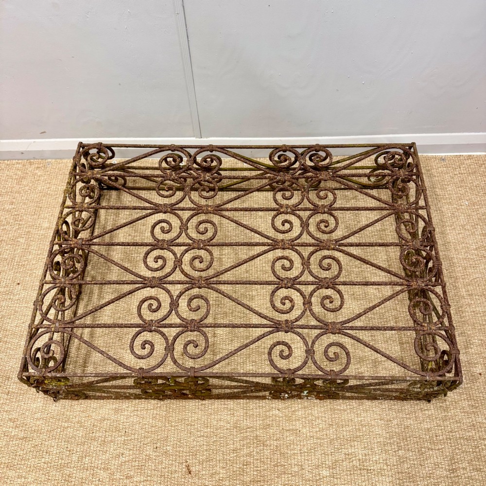 A low rectangular French wrought iron table with ornate C-scroll patterns and a weathered rust finish. View IV