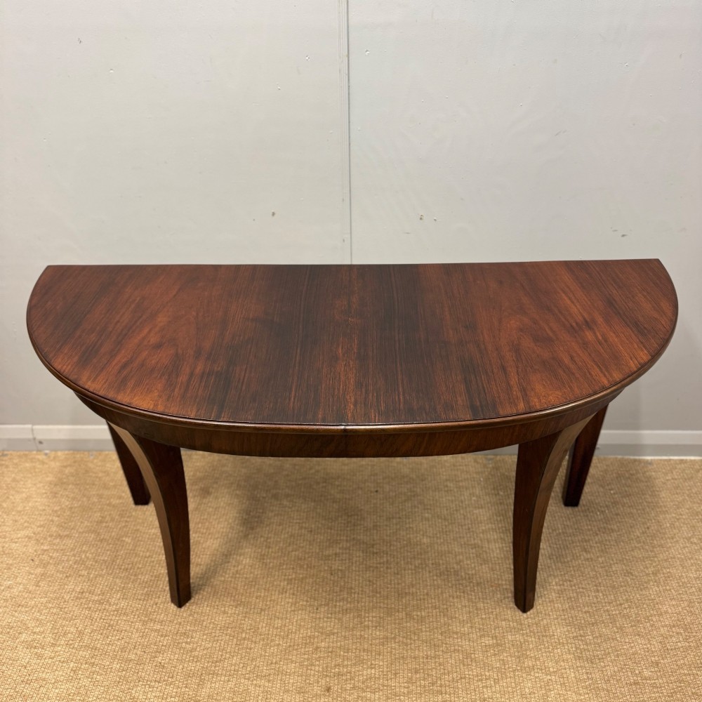 A 19th-century rosewood demilune console table featuring a semi-circular top, plain apron, and four sweeping concave legs. View II