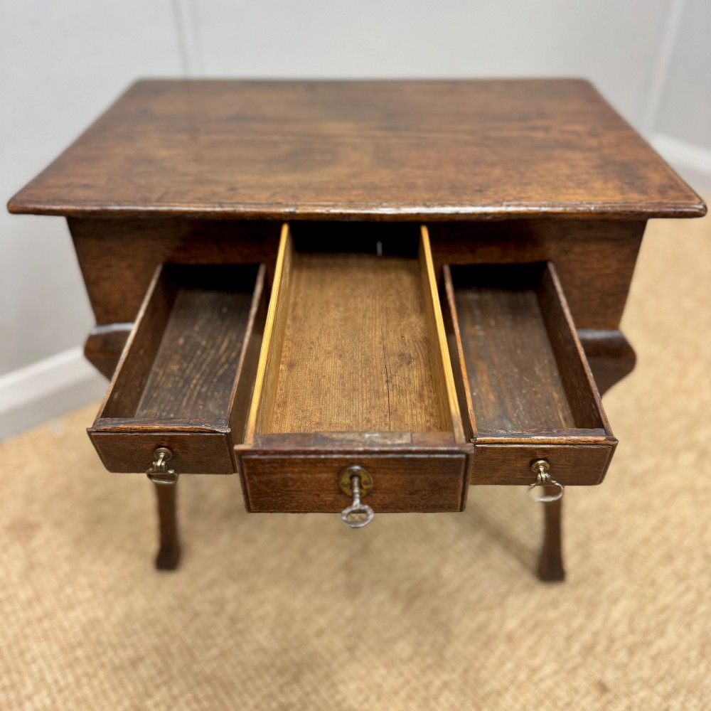 An 18th-century oak low side table featuring cabriole legs, three drawers with brass drop handles, and a shaped apron. View III