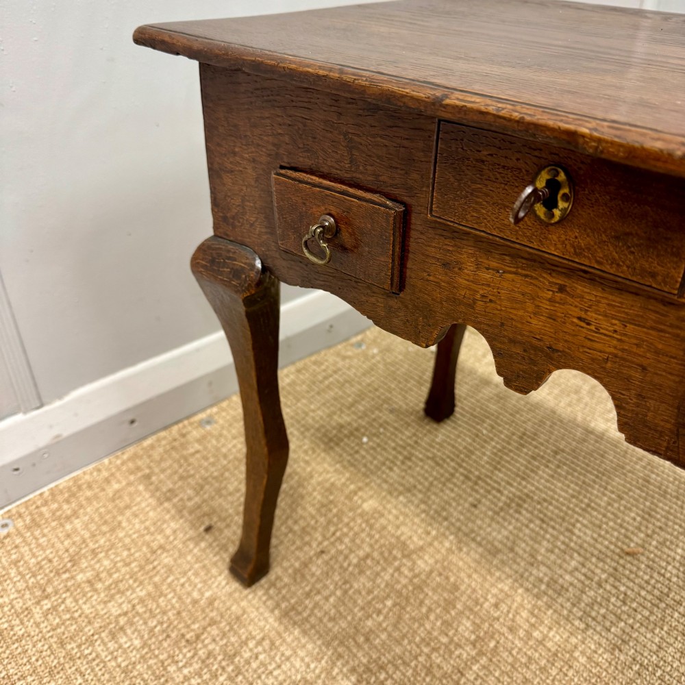 An 18th-century oak low side table featuring cabriole legs, three drawers with brass drop handles, and a shaped apron. View VI