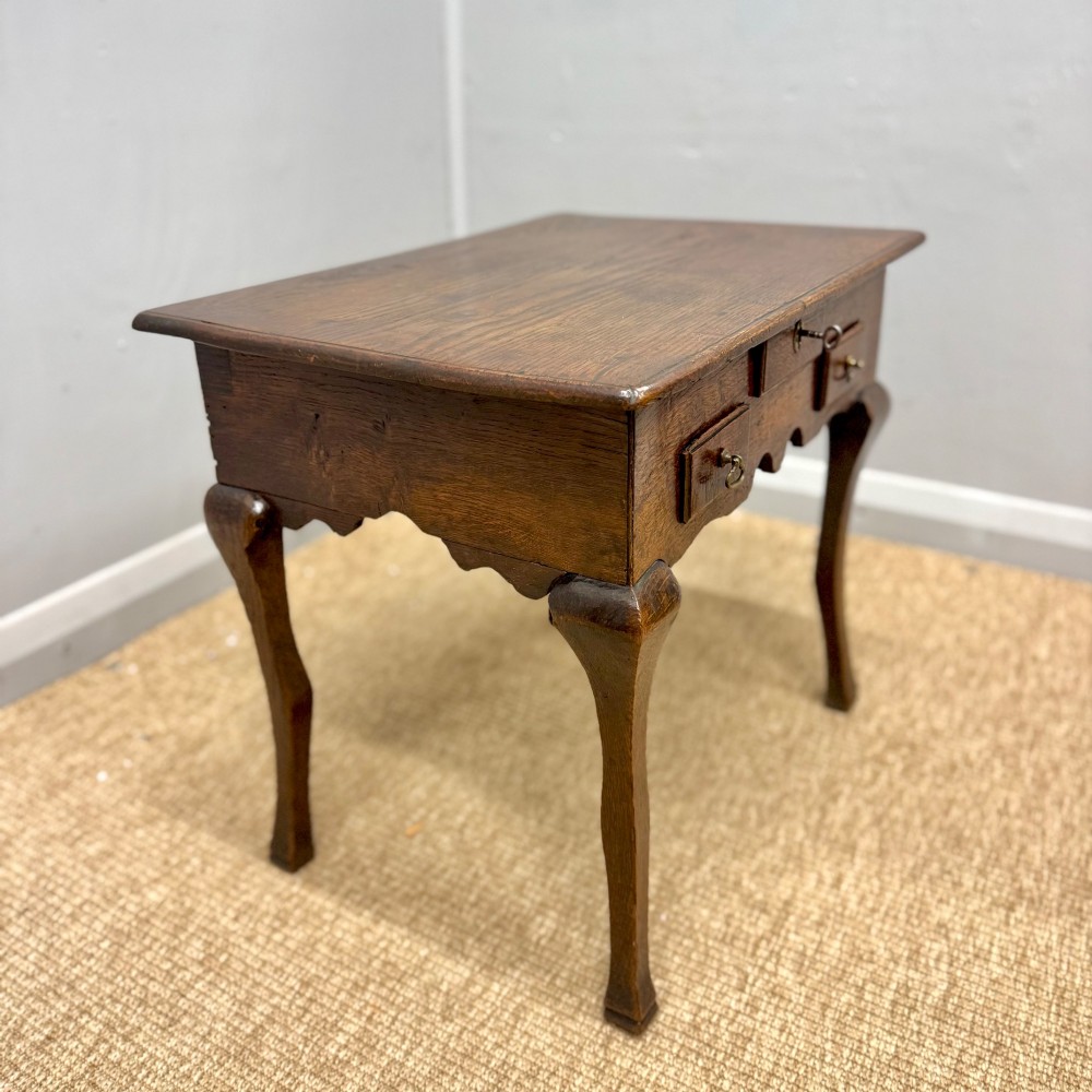An 18th-century oak low side table featuring cabriole legs, three drawers with brass drop handles, and a shaped apron. View VIII