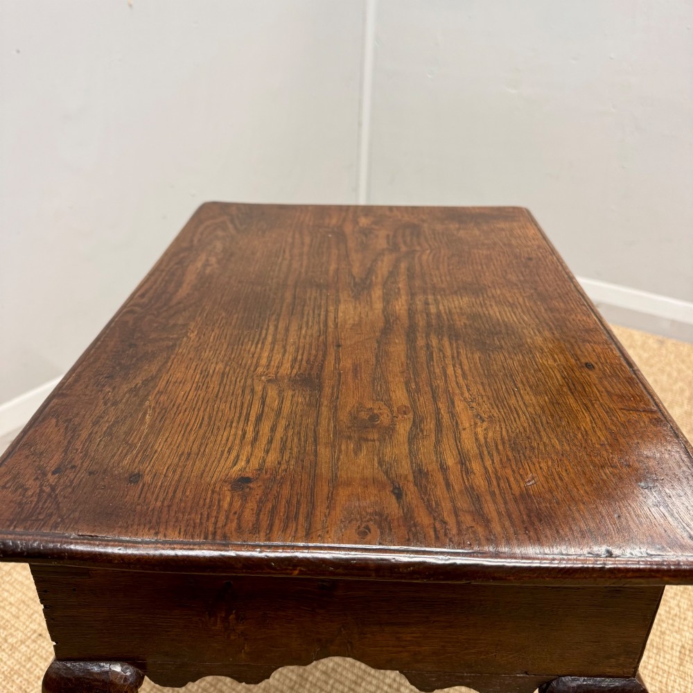 An 18th-century oak low side table featuring cabriole legs, three drawers with brass drop handles, and a shaped apron. View IX