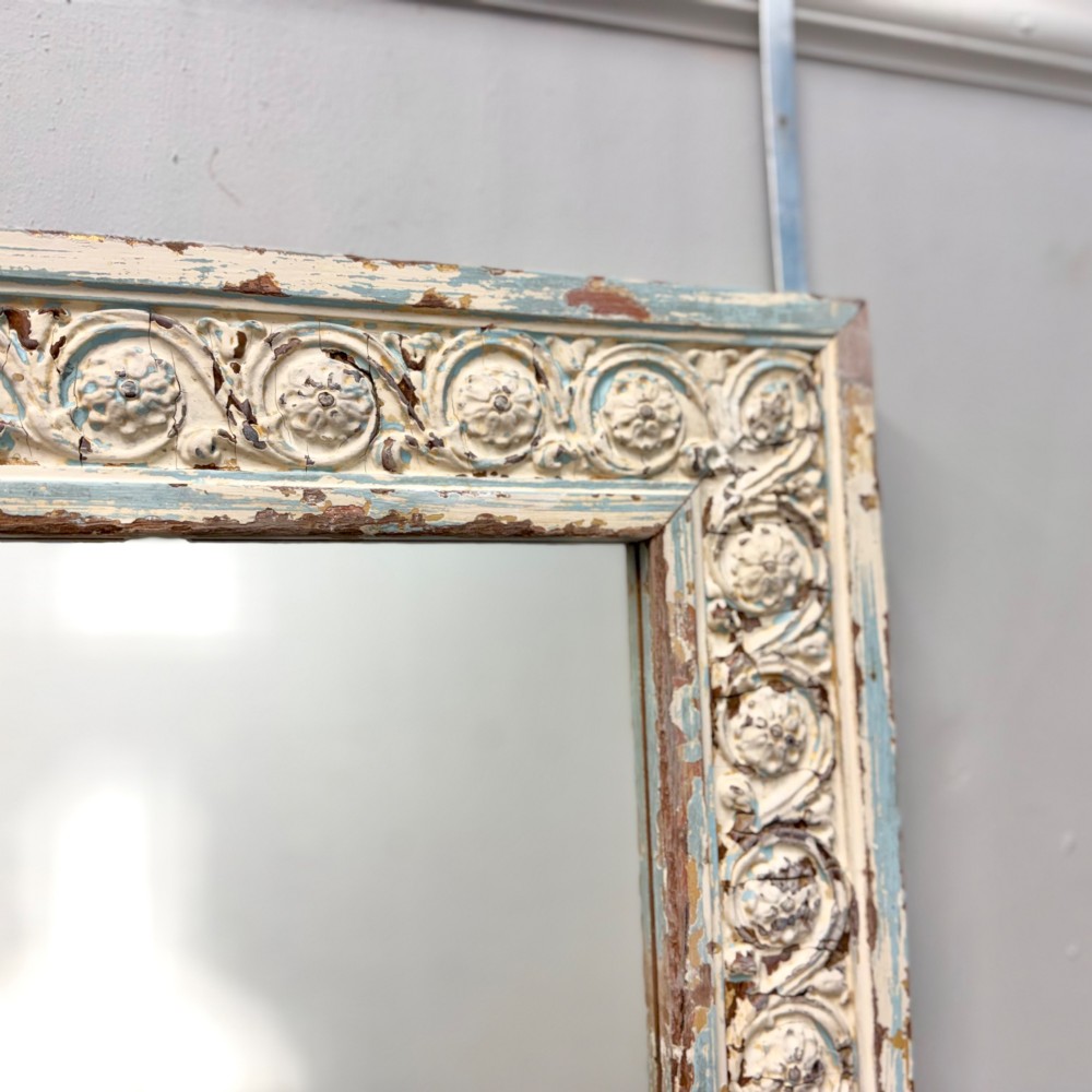 A rectangular 19th-century French overmantel mirror featuring a heavily carved rosette frame with distressed white paint. View II
