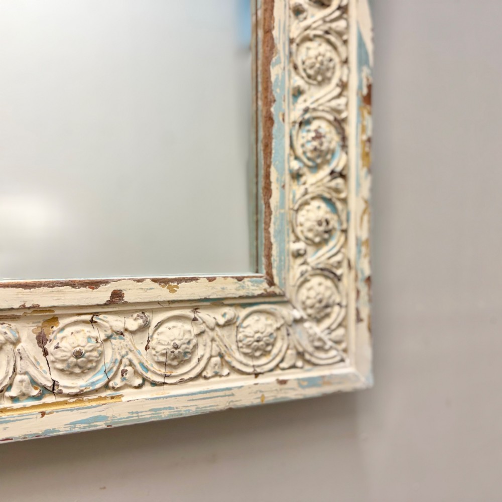 A rectangular 19th-century French overmantel mirror featuring a heavily carved rosette frame with distressed white paint. View III