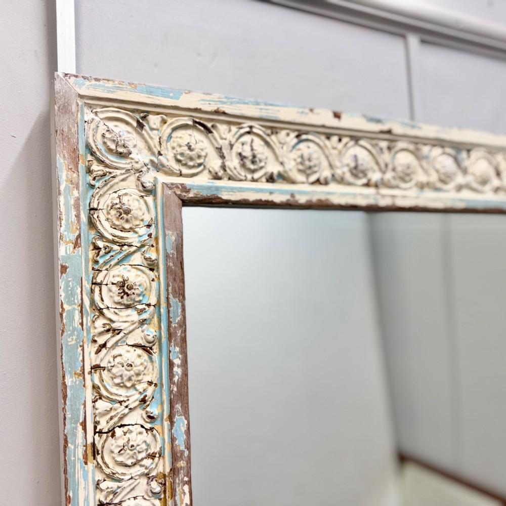 A rectangular 19th-century French overmantel mirror featuring a heavily carved rosette frame with distressed white paint. View VI