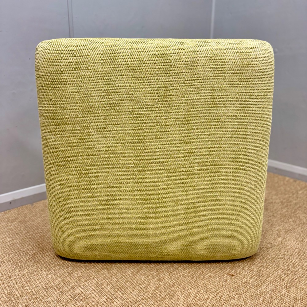 A square footstool upholstered in light green herringbone fabric featuring brass stud trim and four dark turned wooden legs. View IV