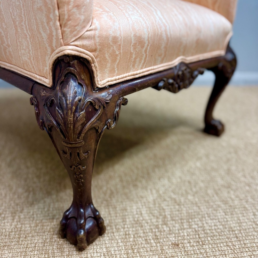 A Georgian armchair upholstered in pale peach damask fabric featuring carved mahogany hipped cabriole legs with claw and ball feet. View II