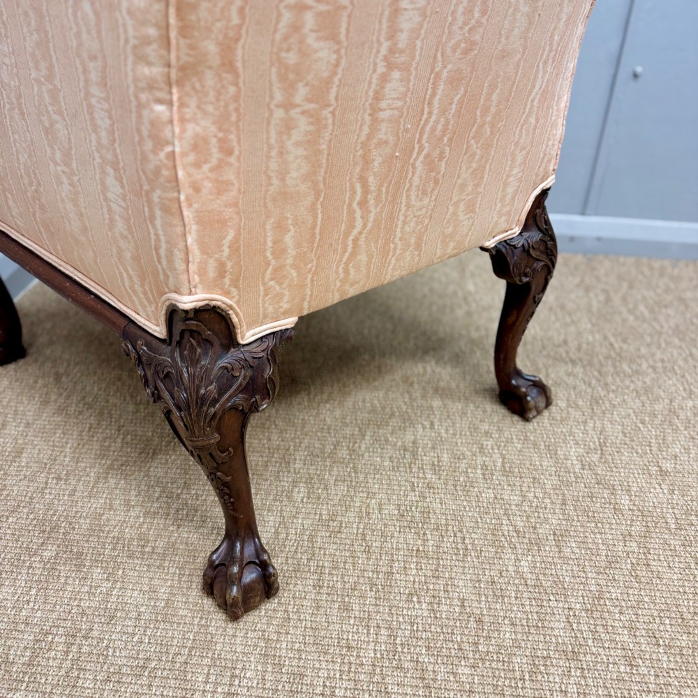A Georgian armchair upholstered in pale peach damask fabric featuring carved mahogany hipped cabriole legs with claw and ball feet. View V