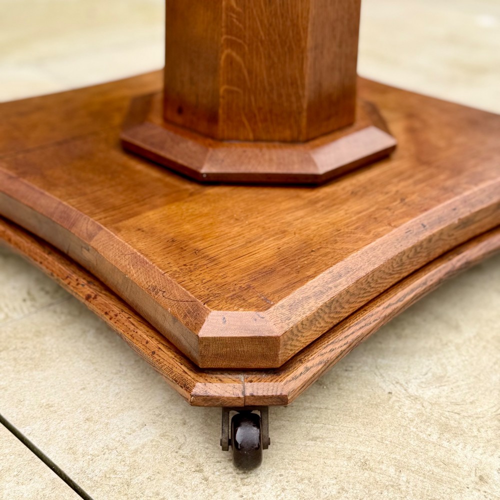 A square antique tilt-top centre table featuring a geometric burr walnut parquetry top framed by an oak border, supported on a faceted pedestal base with castors. View X