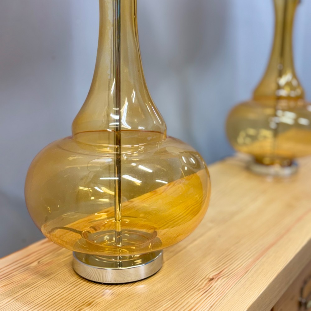 A pair of mid-century amber blown glass table lamps featuring slender necks, bulbous bases, and matching ochre drum shades. View V