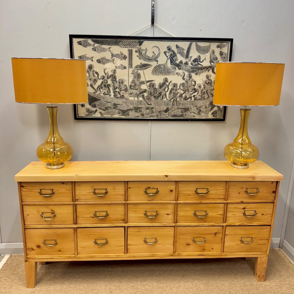 A pair of mid-century amber blown glass table lamps featuring slender necks, bulbous bases, and matching ochre drum shades. View VII