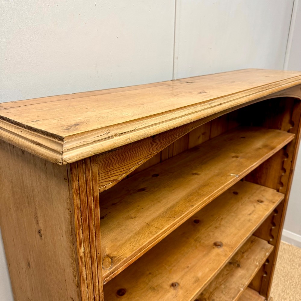 A Victorian open pine bookcase featuring four adjustable shelves, a soft curved top arch, and vertical planked backboards. View V