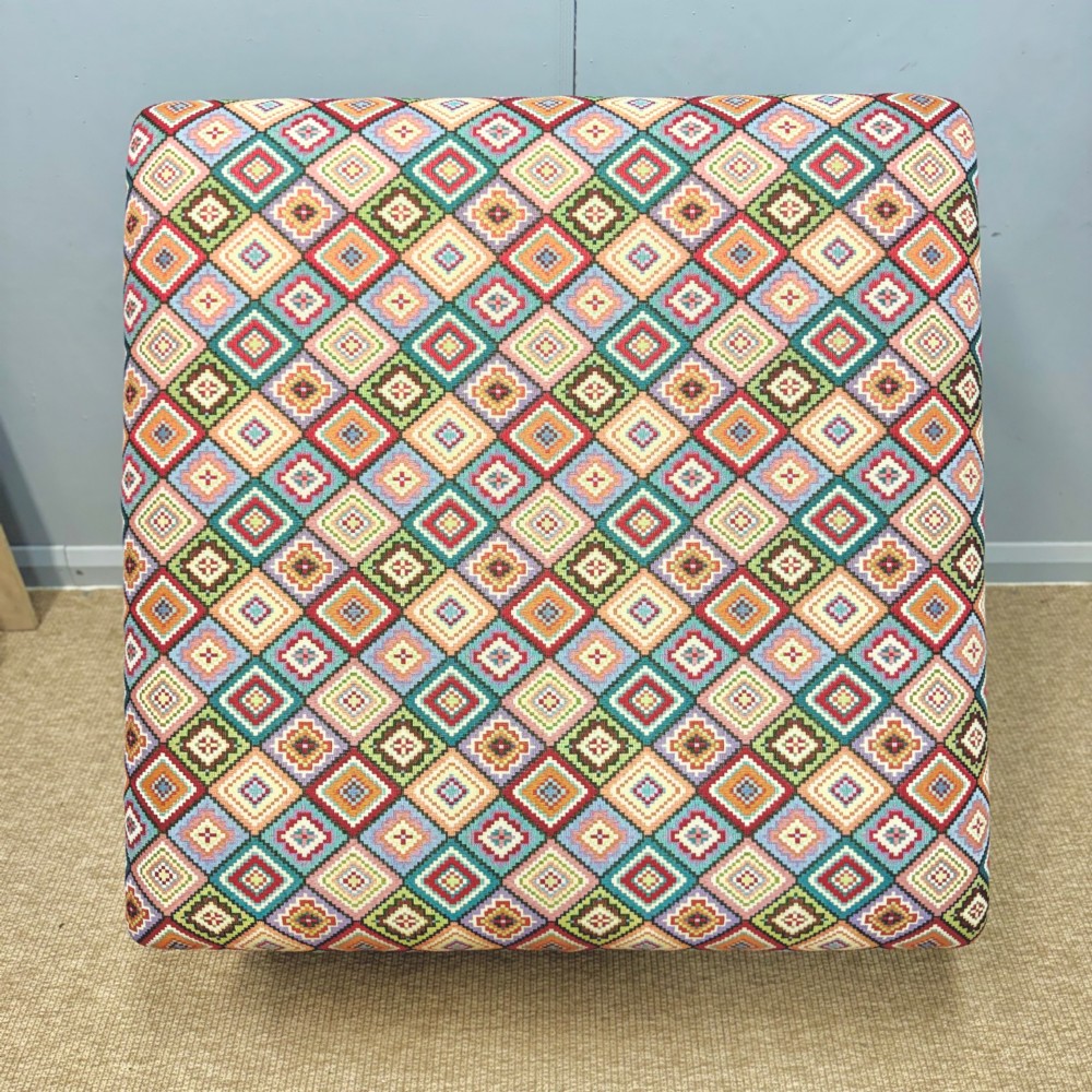 A large rectangular footstool upholstered in a vibrant geometric diamond pattern featuring turned mahogany legs. View V