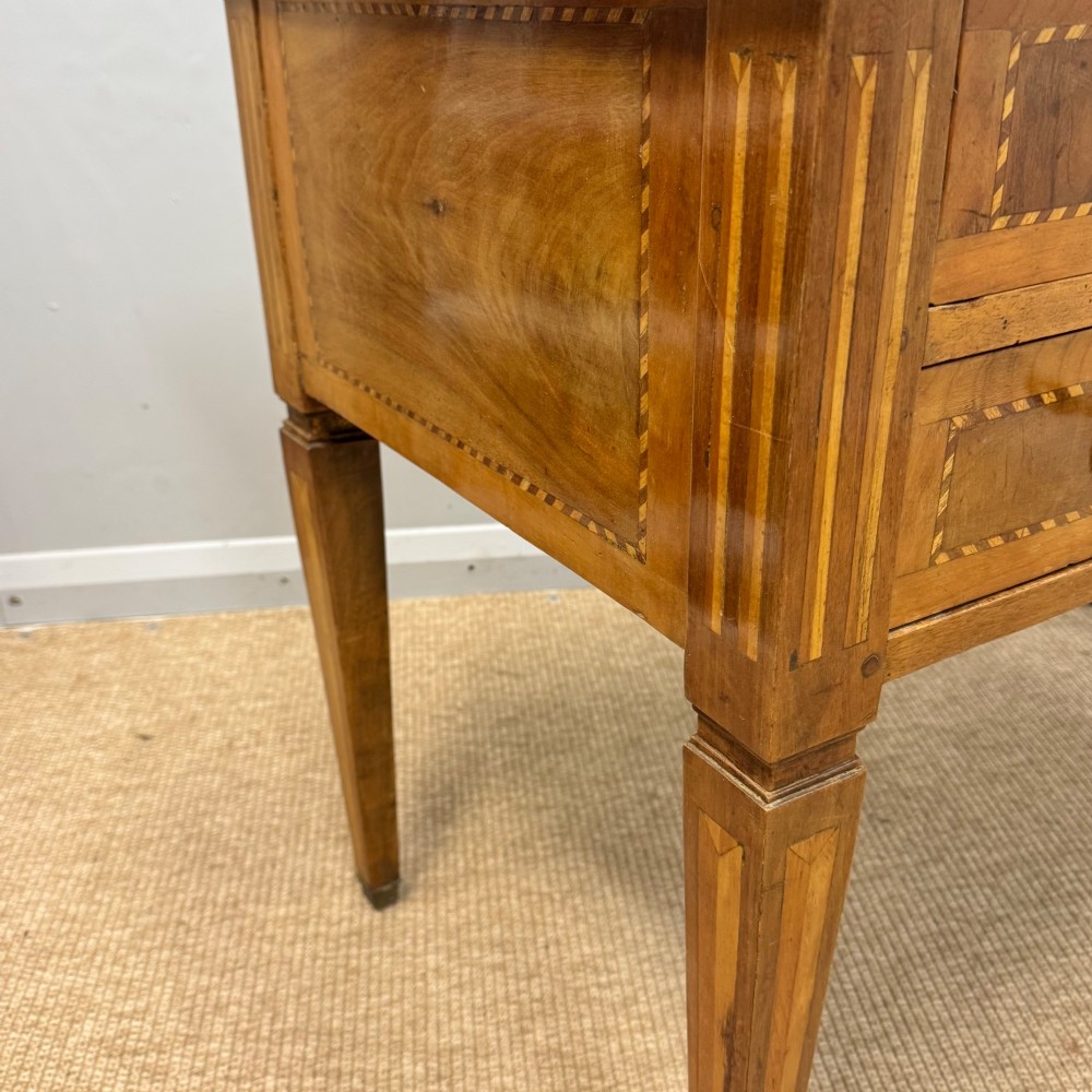 An early nineteenth-century freestanding wood writing desk featuring intricate marquetry inlays, five drawers with brass handles, an arched kneehole, and square tapered legs. View VIII