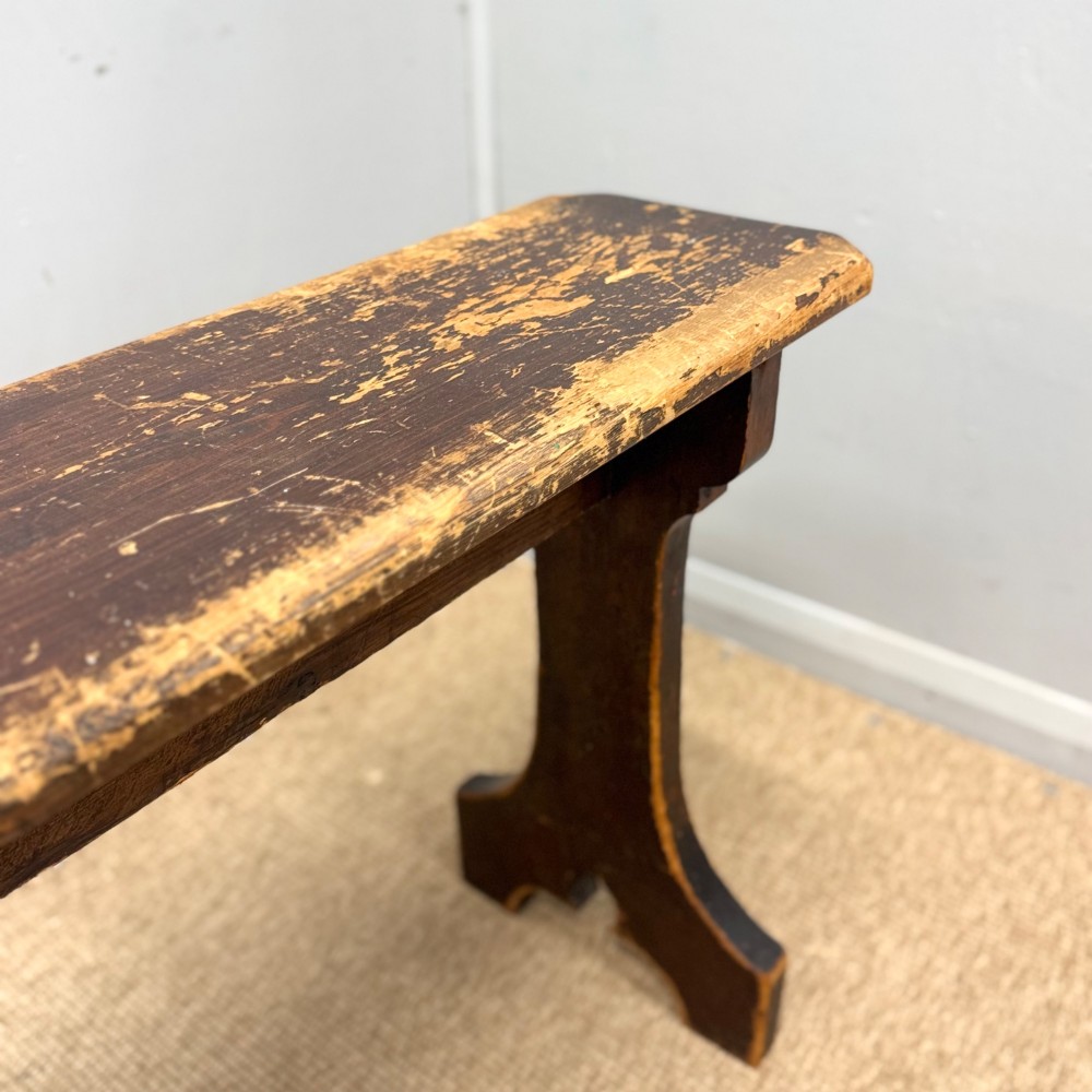 A five-foot antique pine bench featuring a distressed dark brown finish and shaped slab end supports. View III