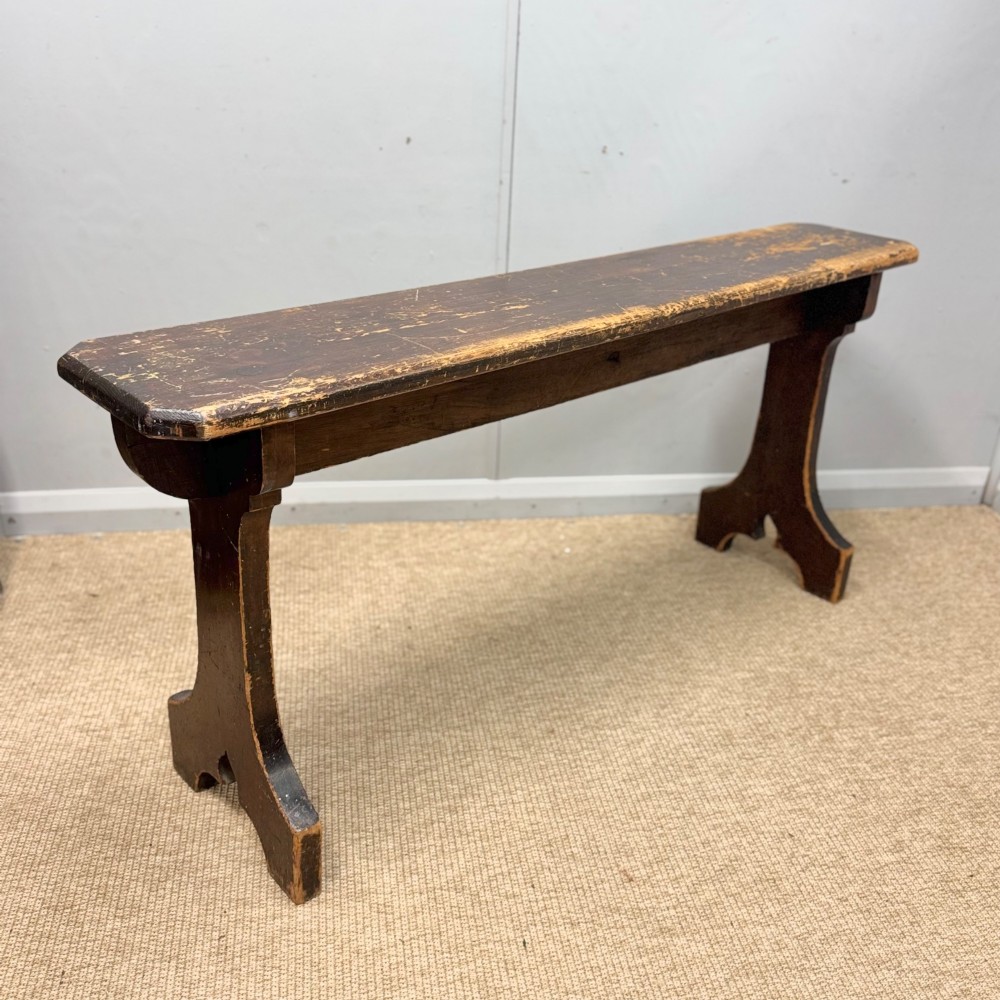 A five-foot antique pine bench featuring a distressed dark brown finish and shaped slab end supports. View IV