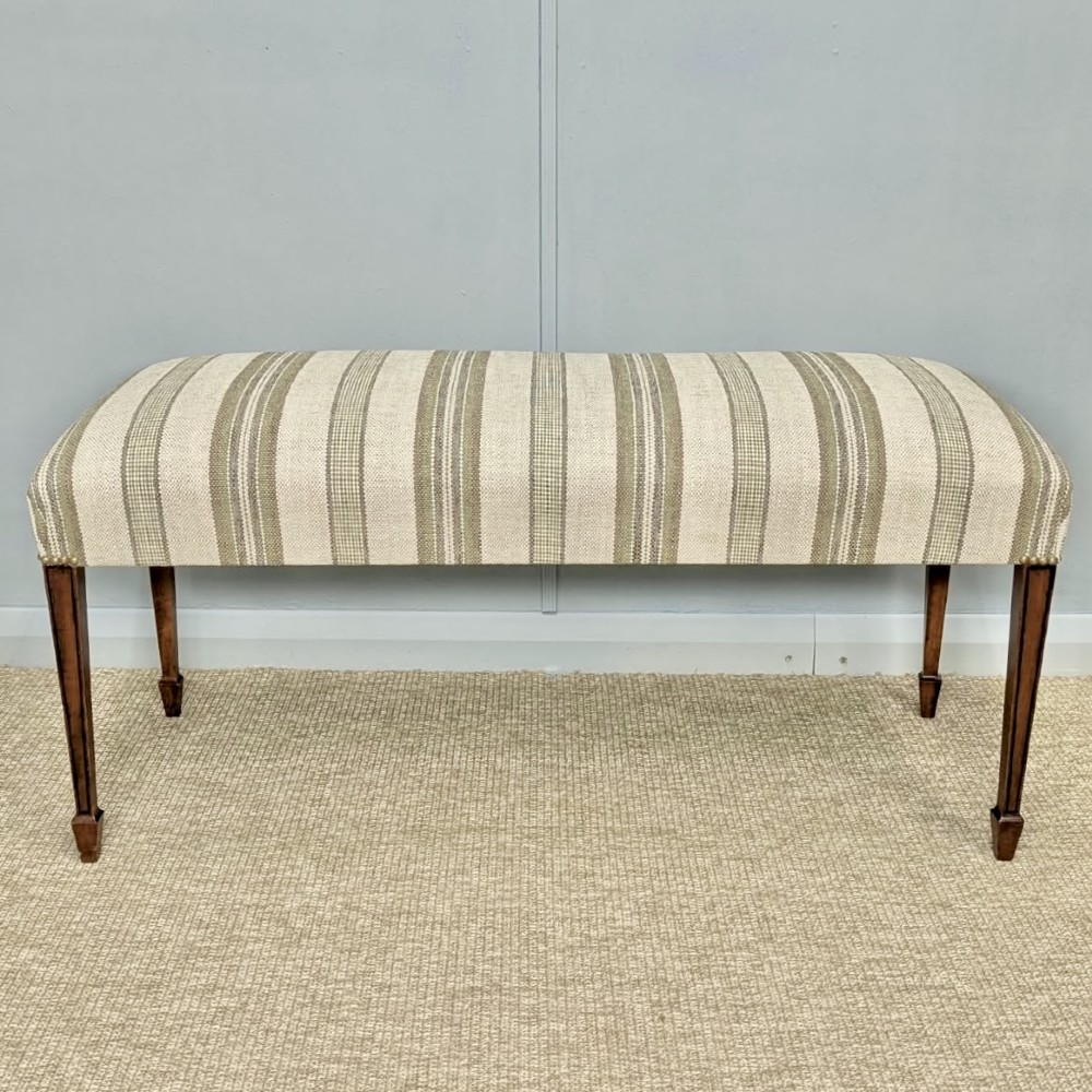 An Edwardian rectangular satinwood piano stool upholstered in beige striped fabric with square tapered legs. View III