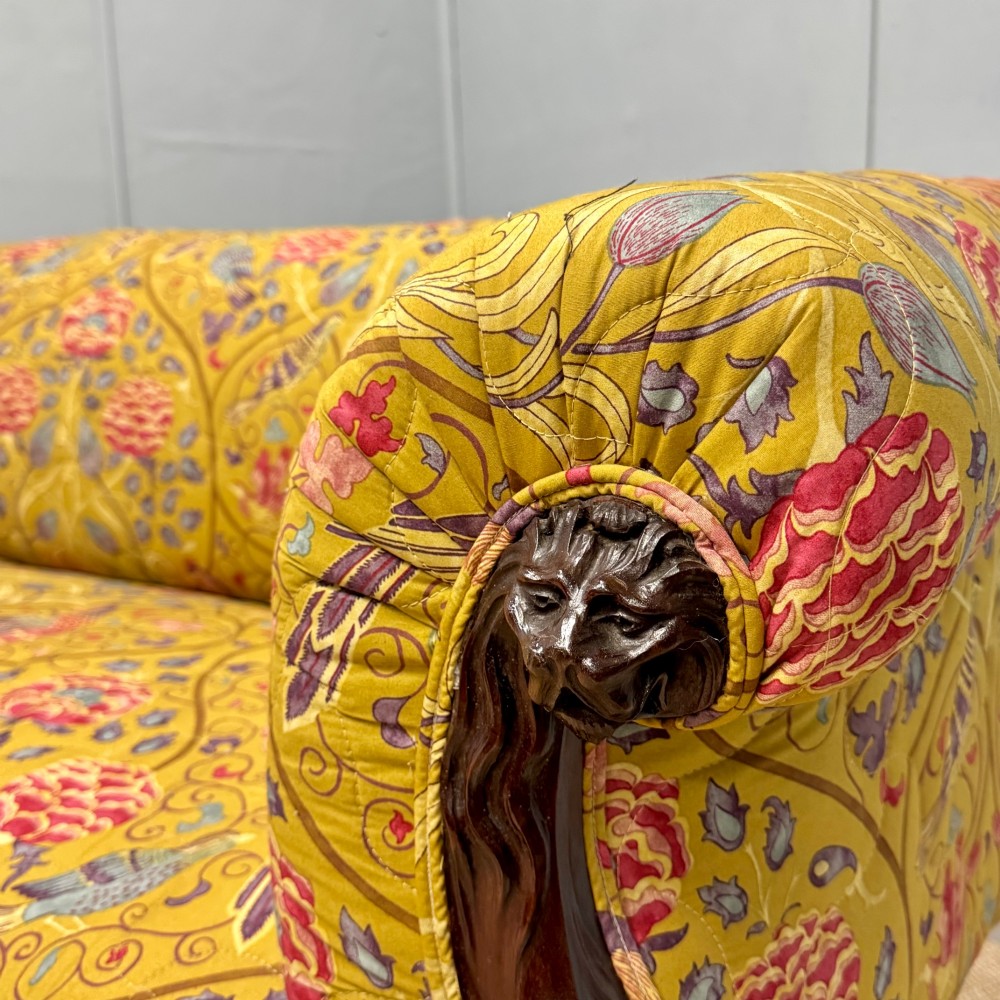 A Late Regency mahogany sofa featuring scroll arms, carved lion mask details, and yellow botanical William Morris style upholstery. View III