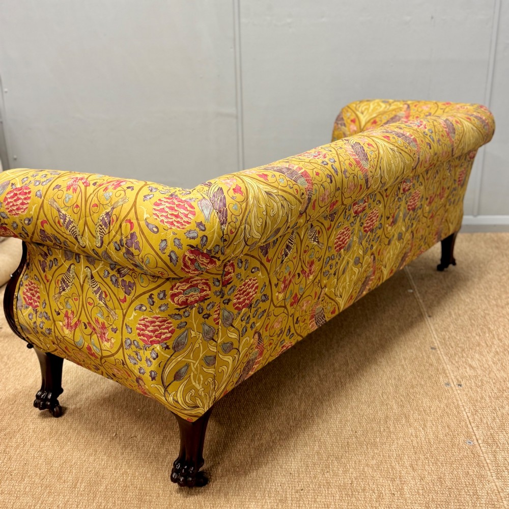 A Late Regency mahogany sofa featuring scroll arms, carved lion mask details, and yellow botanical William Morris style upholstery. View VIII