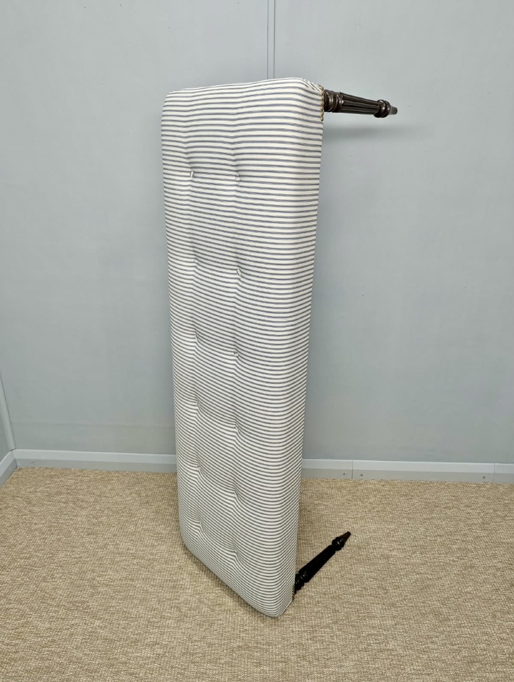 A pair of long upholstered benches featuring grey and white striped ticking fabric with deep button tufting set upon dark turned and fluted timber legs. View IV