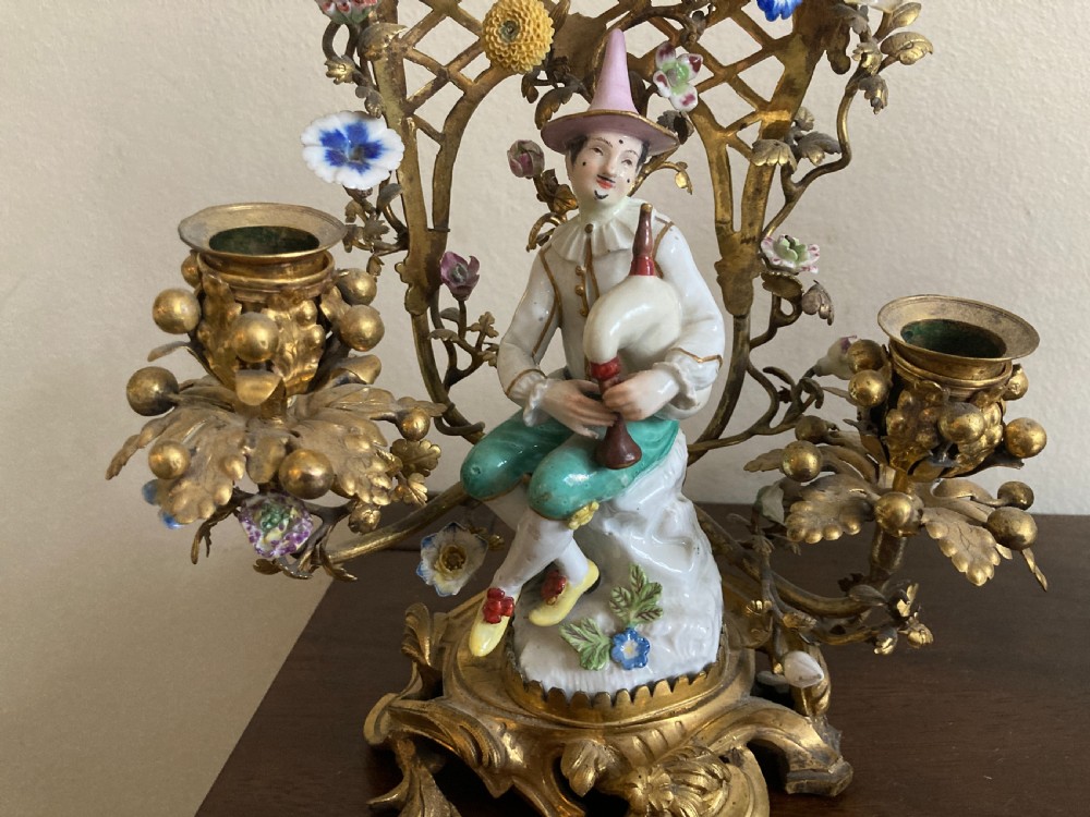 A pair of 18th-century Rococo gilt bronze candelabra featuring seated Meissen porcelain musician figures against floral trellis backdrops. View II