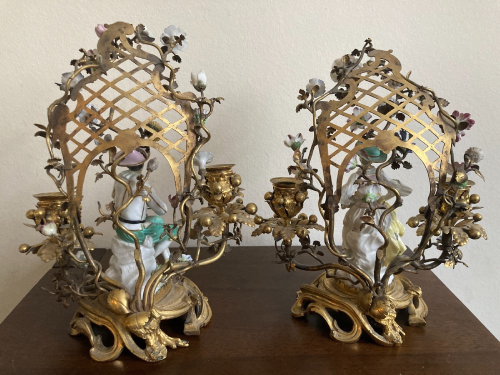 A pair of 18th-century Rococo gilt bronze candelabra featuring seated Meissen porcelain musician figures against floral trellis backdrops. View VI