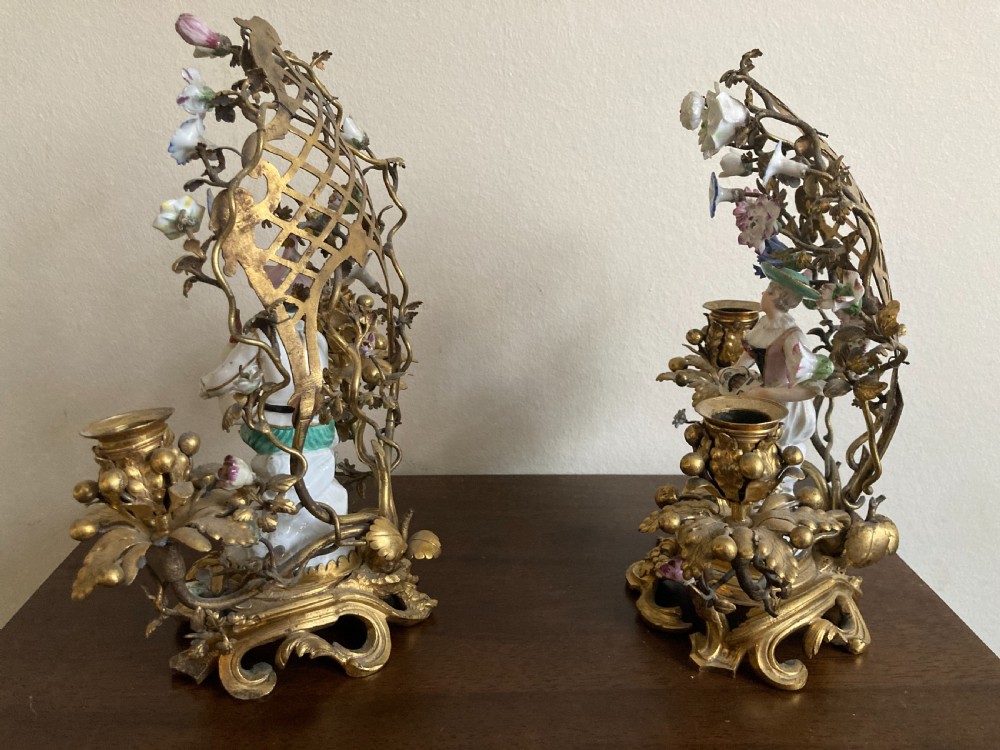 A pair of 18th-century Rococo gilt bronze candelabra featuring seated Meissen porcelain musician figures against floral trellis backdrops. View VII